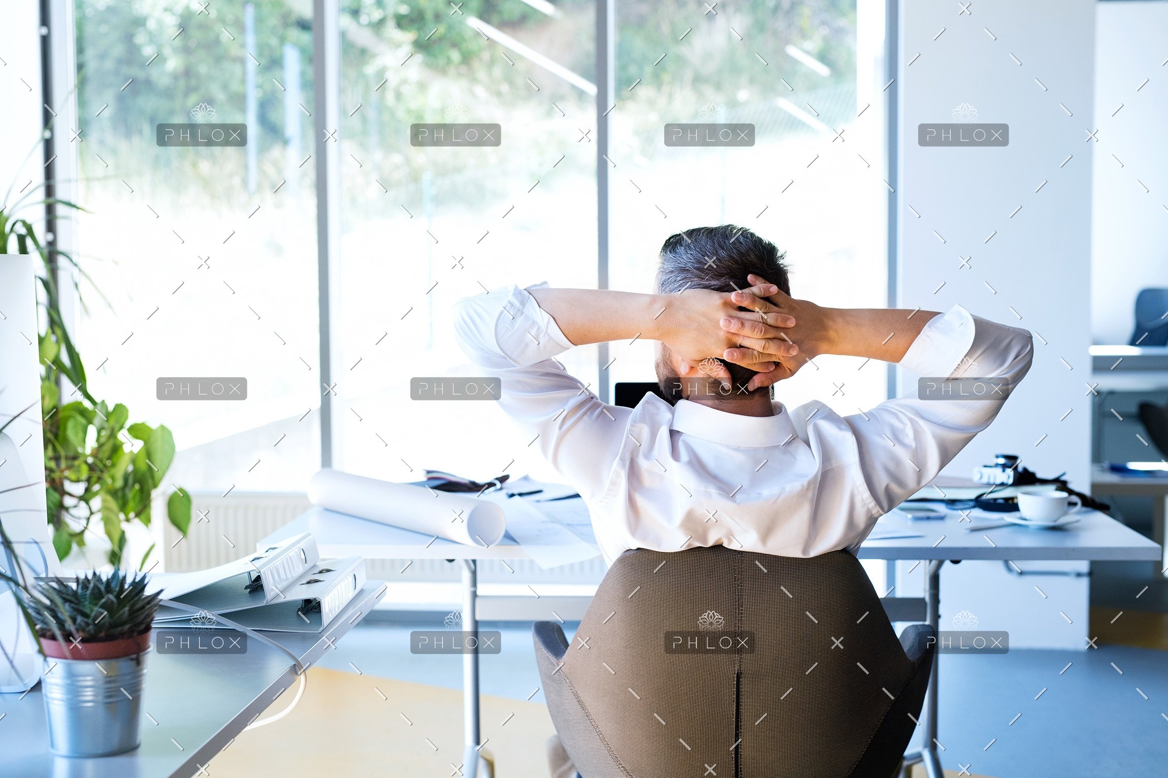 Businessman-at-the-desk-in-his-office-resting.
